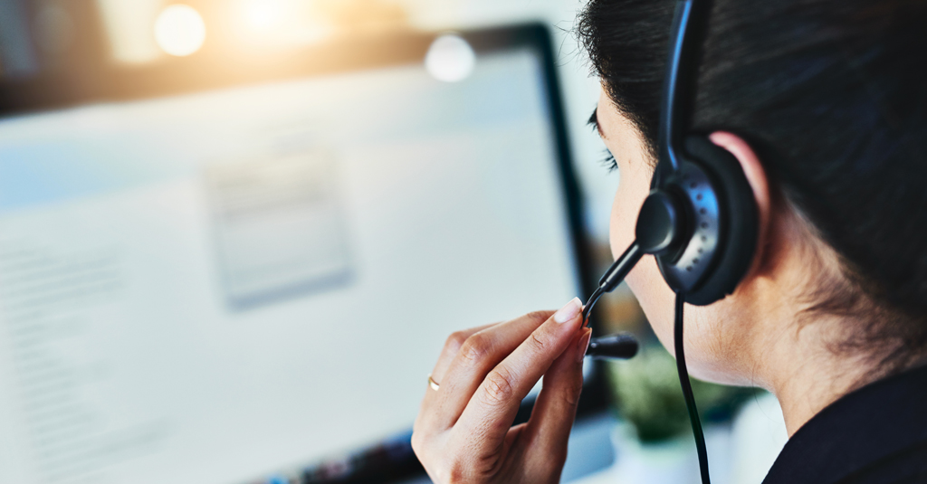 Woman wearing a phone headset sitting at a computer