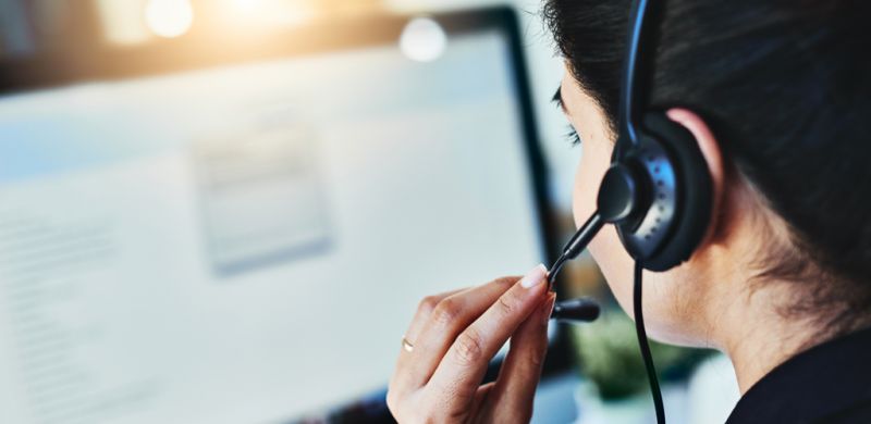 Woman wearing a phone headset sitting at a computer