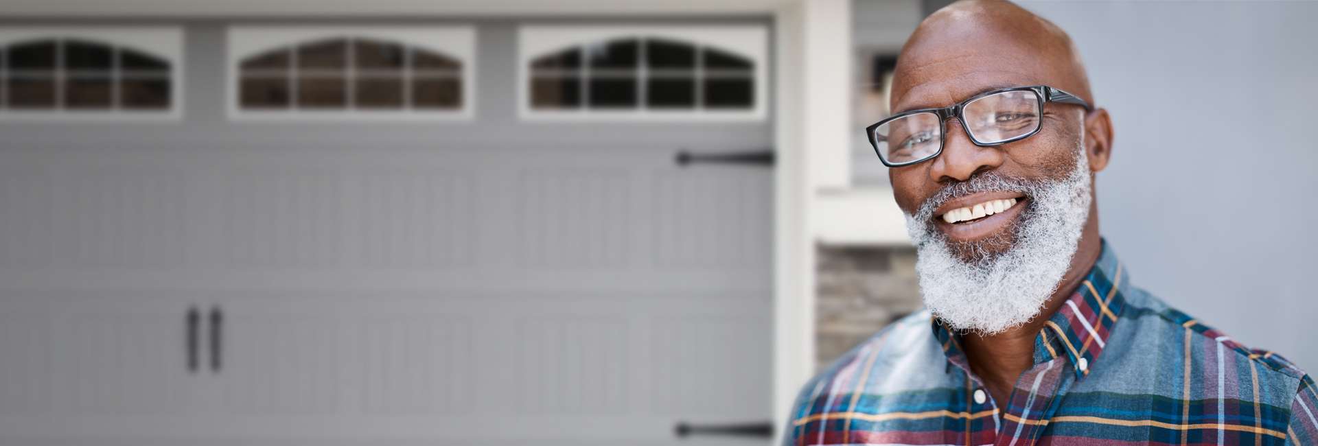 A man smiles in front of a house.